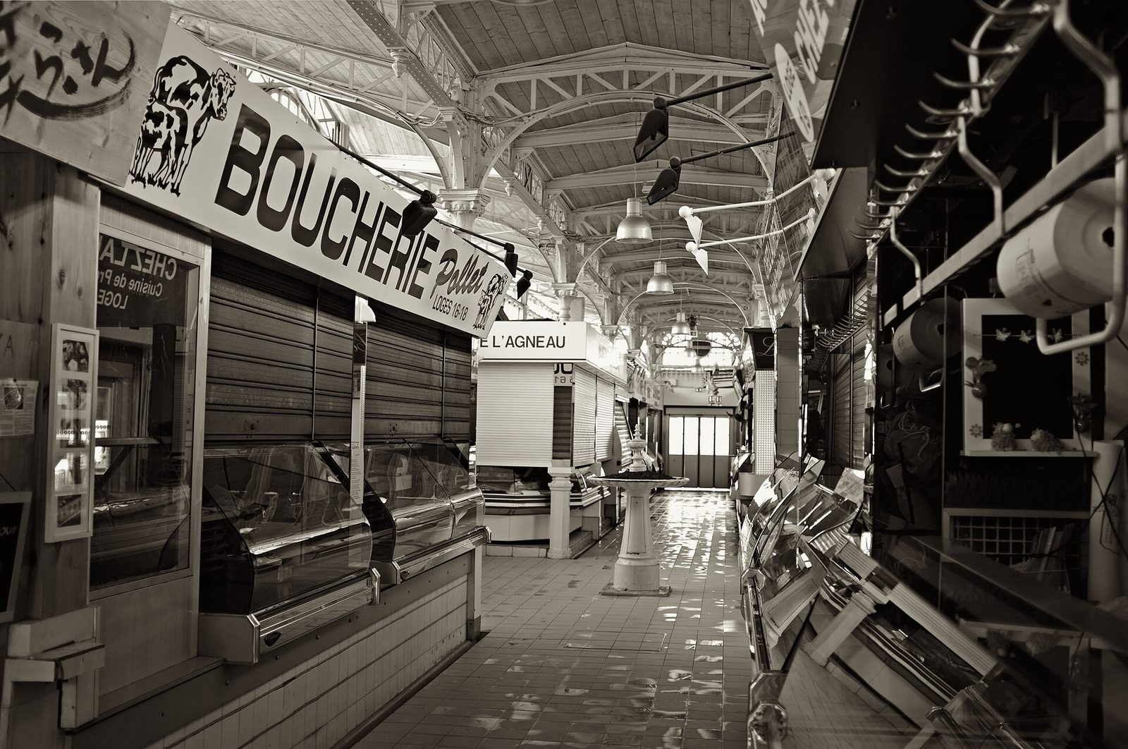 Intérieur d'un marché couvert avec commerces et étals